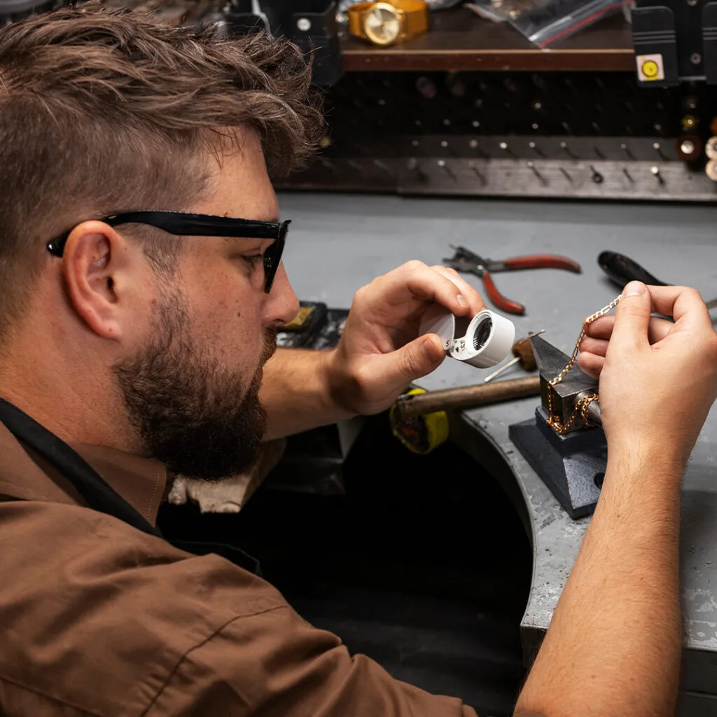 Locksmith examining a small lock mechanism under magnification, highlighting emergency locksmith near me precision repair services.