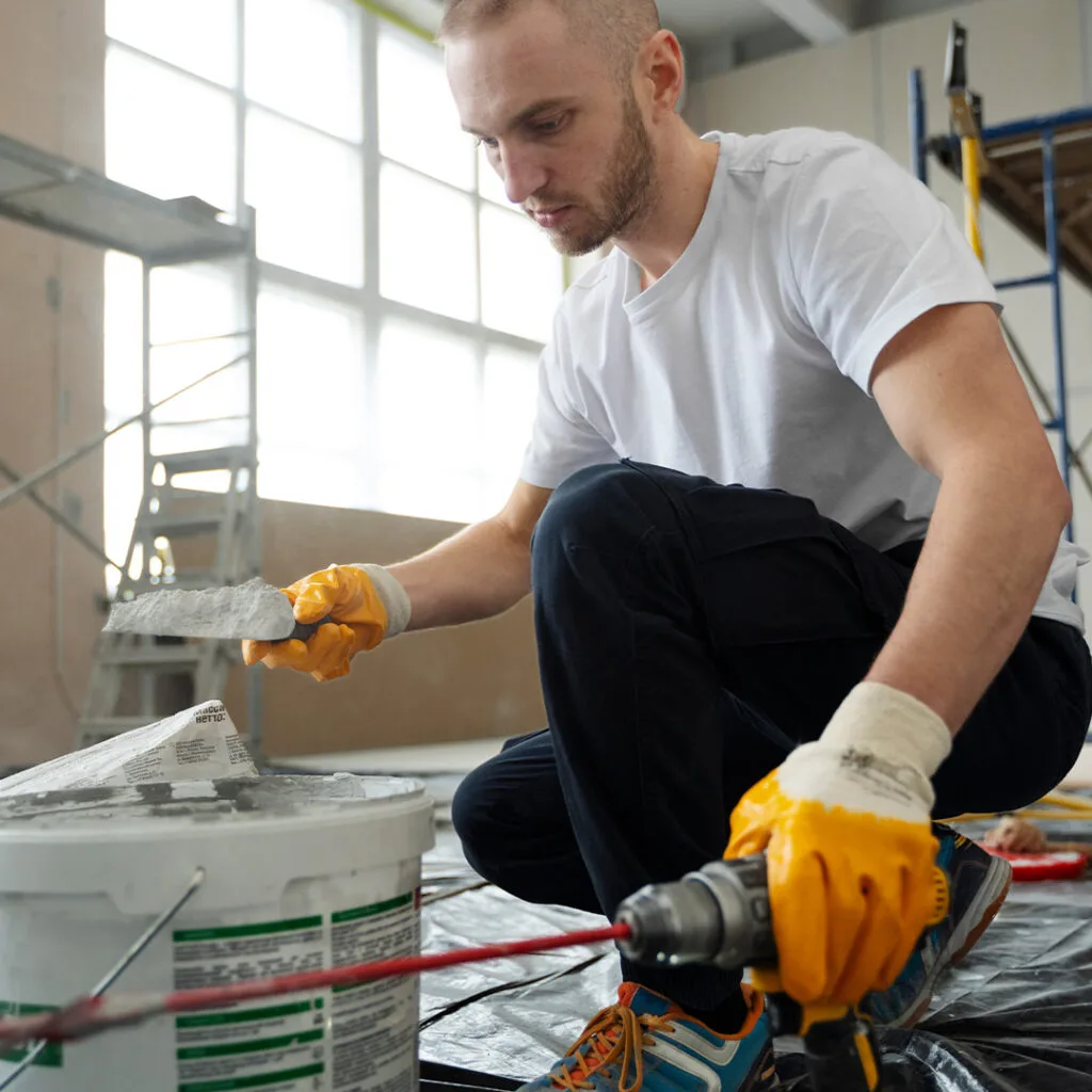 Contractor mixing and preparing materials for interior repairs, a key step in mold remediation near me for water-damaged spaces.