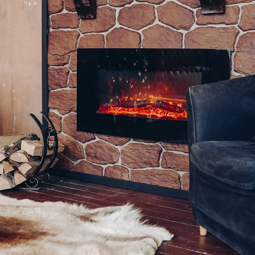 Electric fireplace with glowing embers set into a stone accent wall, representing a clean and cozy setup after a chimney sweep near me.