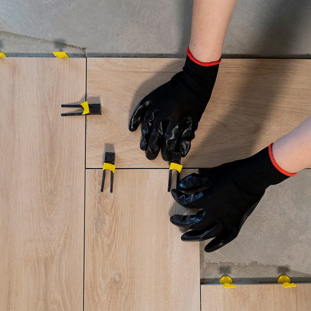 Flooring installers near me aligning wooden tiles with spacers and leveling clips during precision floor installation.
