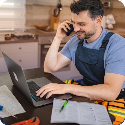 Electrician talking on the phone while using a laptop