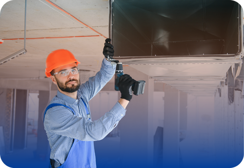 HVAC technician wearing a hard hat and safety glasses installing an air duct with a power drill.