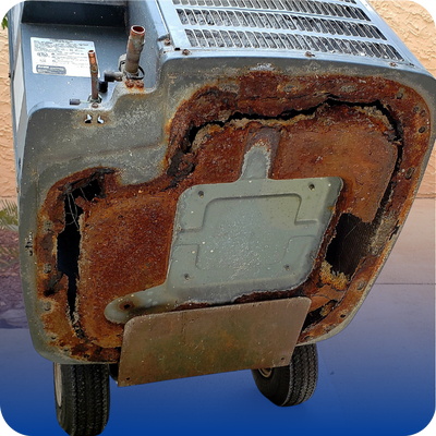 A rusty, old air conditioner on wheels, showing signs of wear and age, positioned against a neutral background.