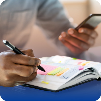 A contractor writing notes in a notebook, focused on project details for homeowners.