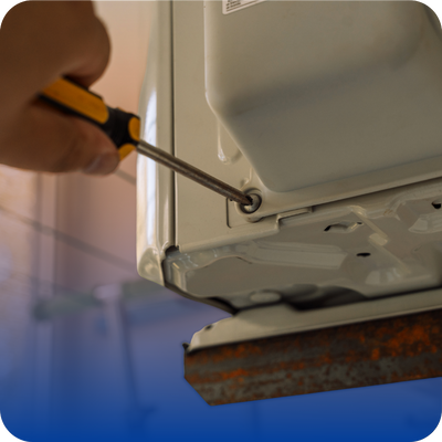 A person gripping a screwdriver while working on a metal object, showcasing a practical skill in tool use.