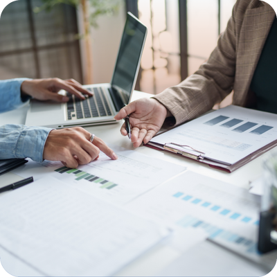 A group of business professionals collaborating on a laptop, discussing project details and strategies.