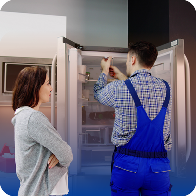 A man and woman stand together in front of an open refrigerator, discussing its contents.