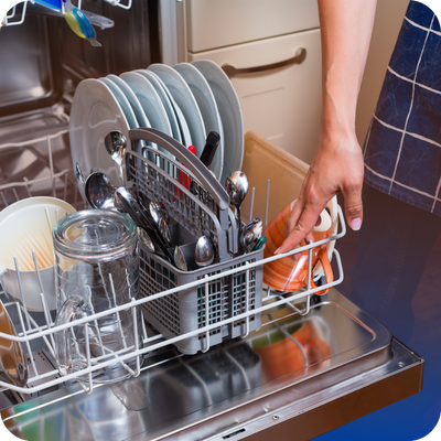 An individual organizing dishes inside a dishwasher, highlighting the process of preparing for a wash cycle.